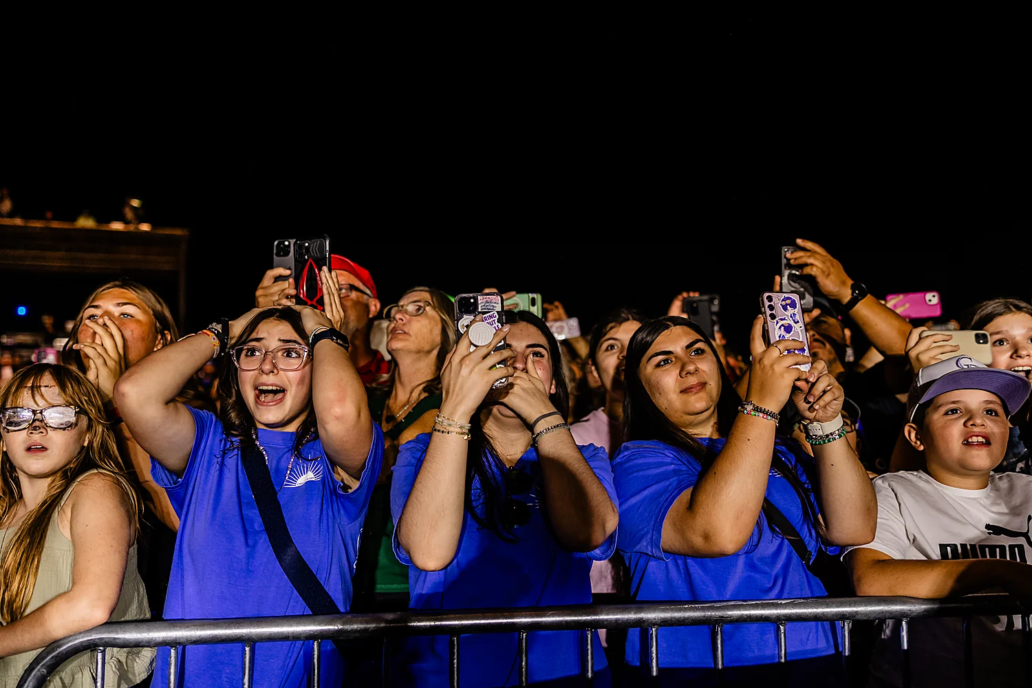 Young festivalgoers cheering at the front barrier