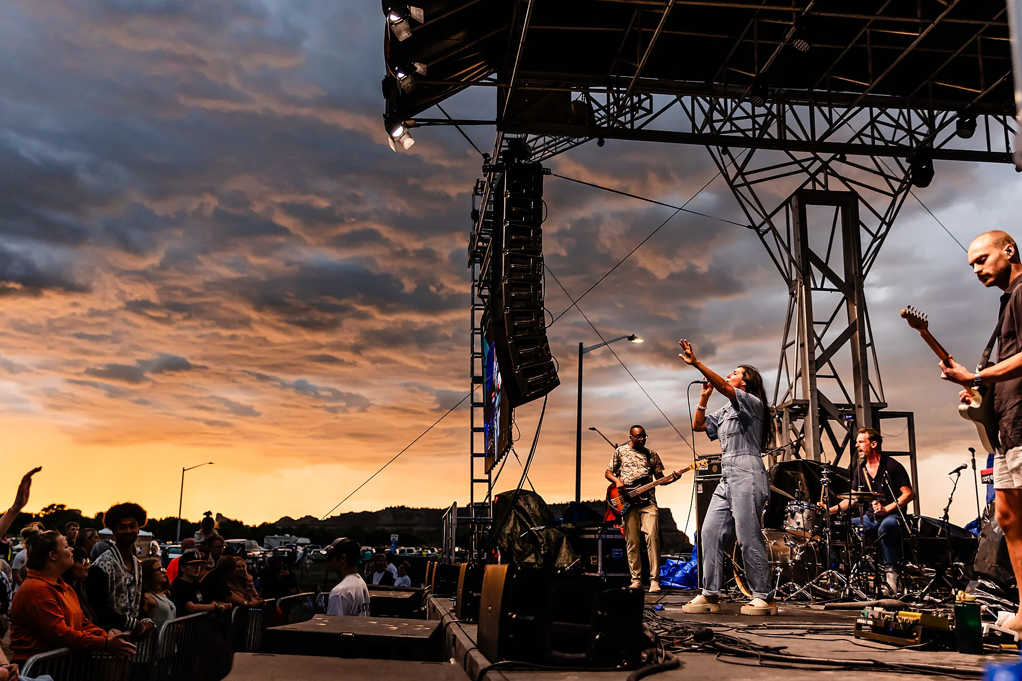 A band leads worship on the Horizon stage as the Nebraska sky burns gold at sunset, the crowd gathered below