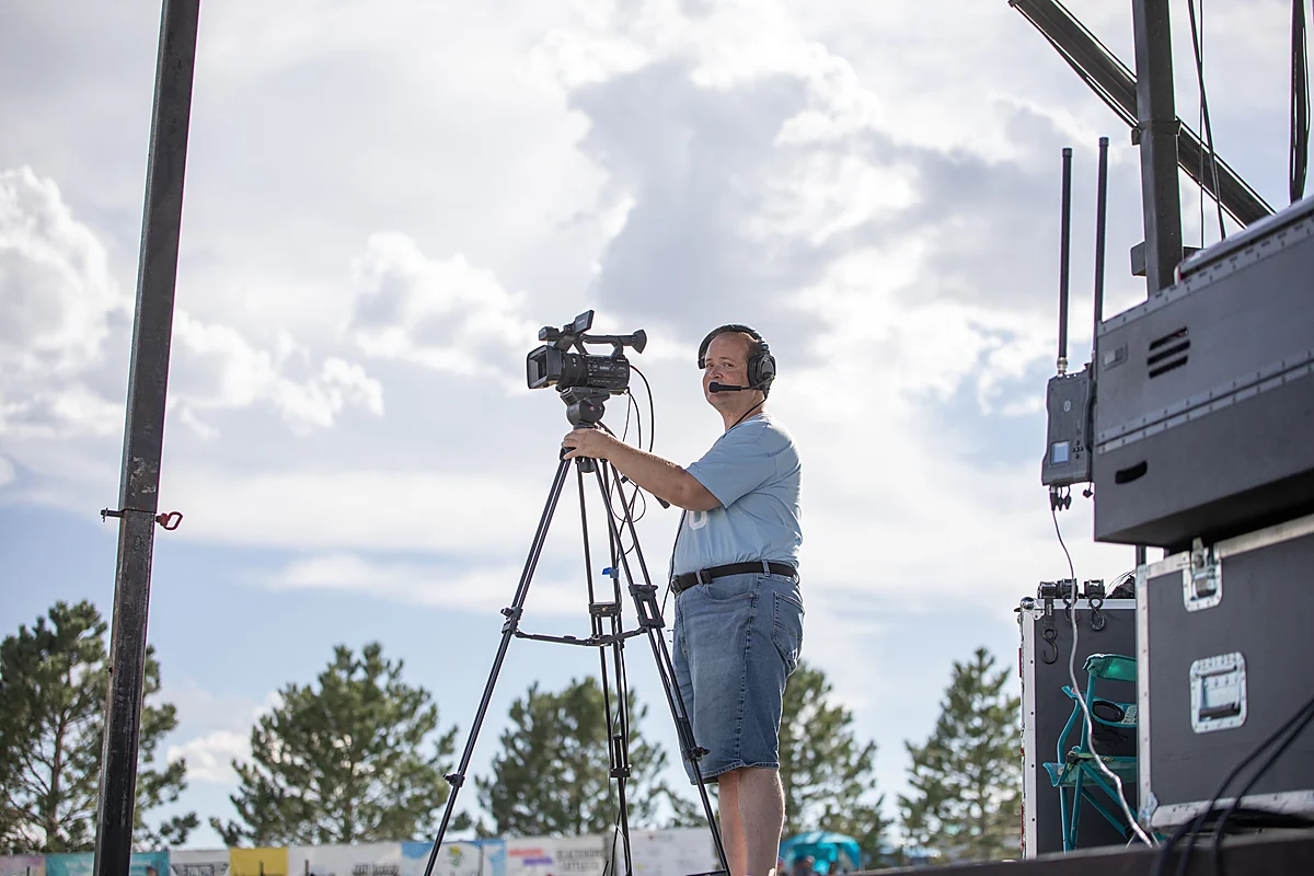 A volunteer running a video camera beside the main stage