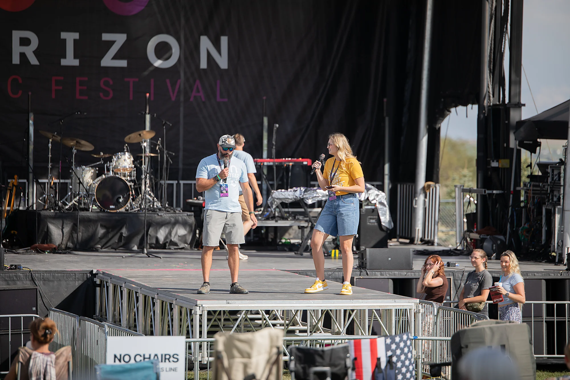 Volunteers with microphones on the Horizon Music Festival stage in 2026