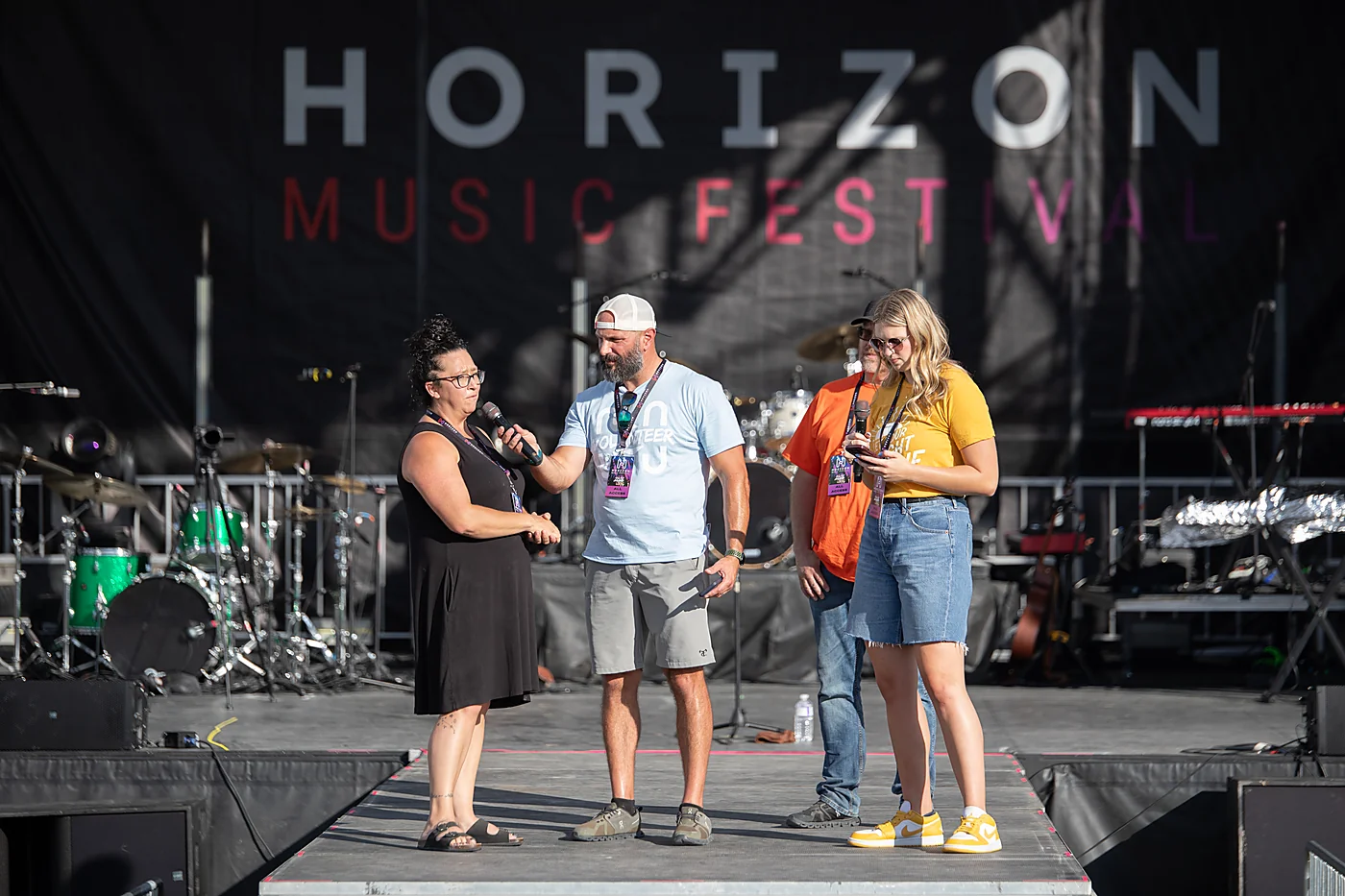 A volunteer thanked on stage in front of the Horizon Music Festival backdrop